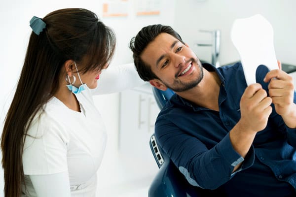Dentist examining patient teeth for dentin discoloration and darkening Dentist examining patient teeth for dentin discoloration and darkening