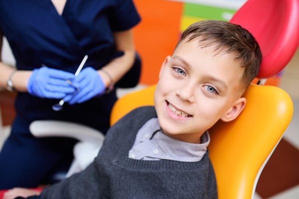 Young boy sitting in dental chair and smiling. Young boy sitting in dental chair and smiling.