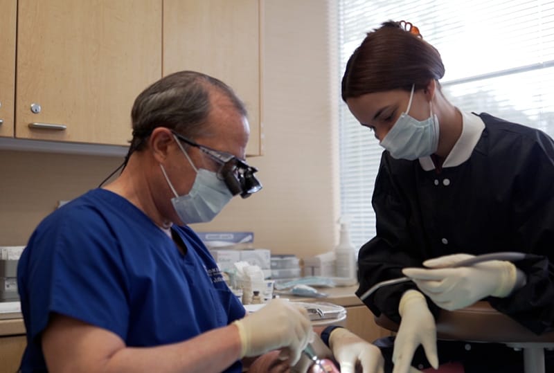 Dr. Jutkowitz and a dental assistant performing a procedure on a patient that is comfortably sedated.