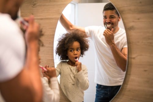 Dad and daughter brushing teeth