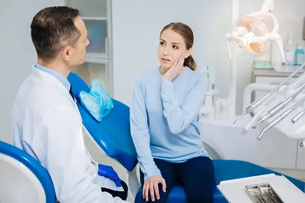 Patient discussing diet-related tooth pain with dentist during dental visit