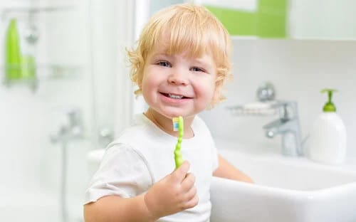 Happy baby boy brushing teeth