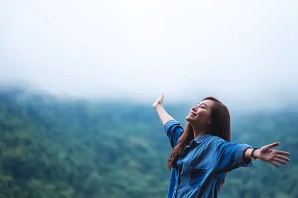 Woman breathing through nose outdoors demonstrating closed-mouth breathing benefits