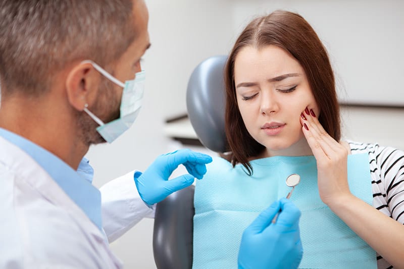 Young woman exhibiting tooth pain Young woman exhibiting tooth pain