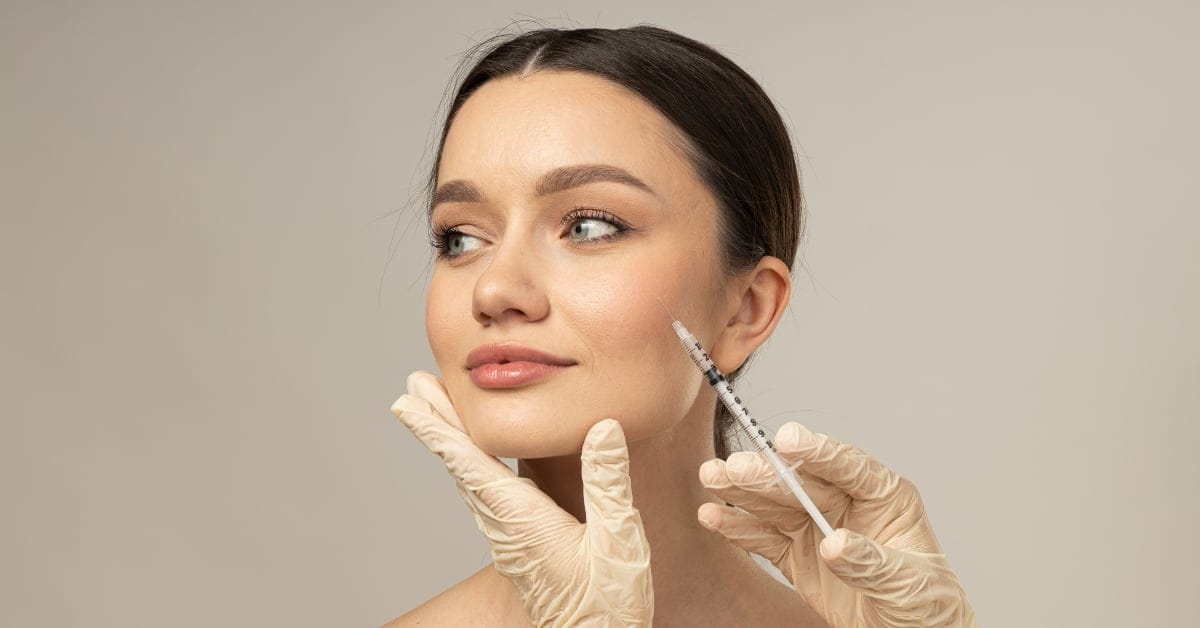 A woman receiving a Botox injection from a gloved practitioner A woman receiving a Botox injection from a gloved practitioner