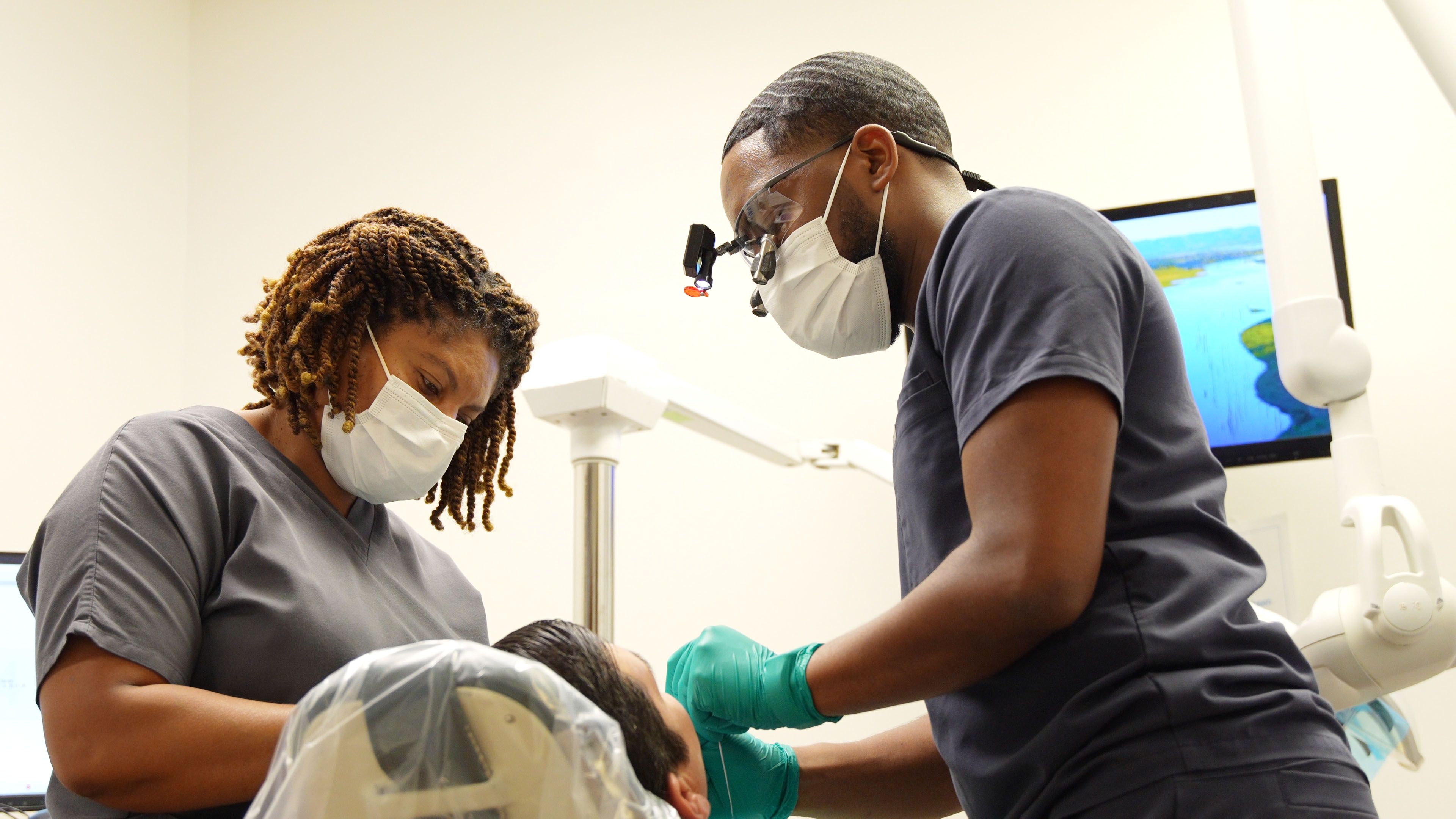 Dr. Thierry Lamour, DDS perform dental exam on patient